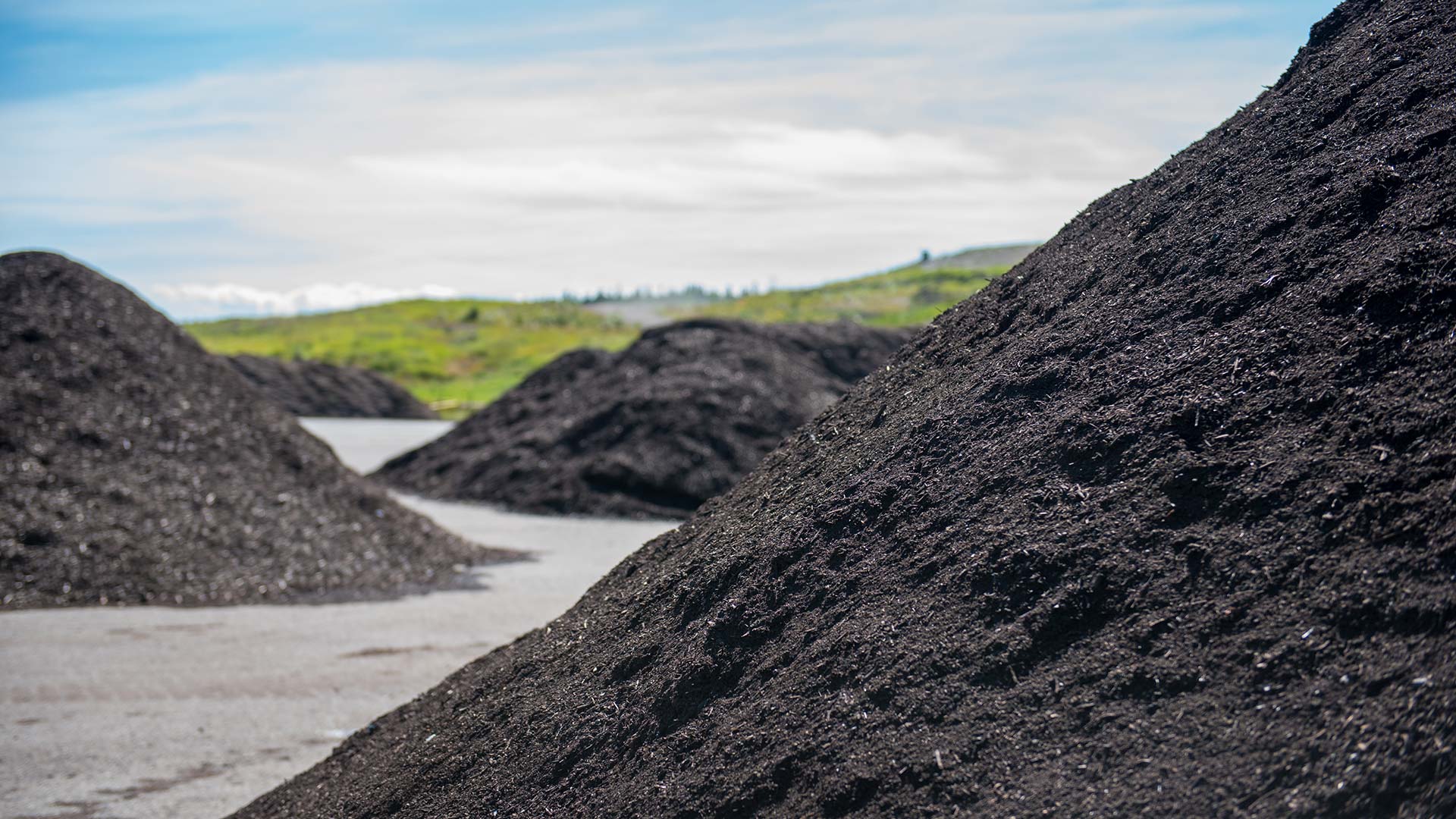 Several piles of mulch and soil created using compost